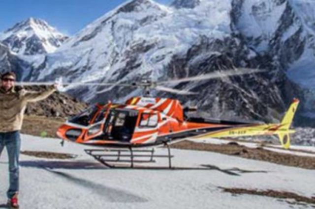 Helicopter in front of snowy mountain range