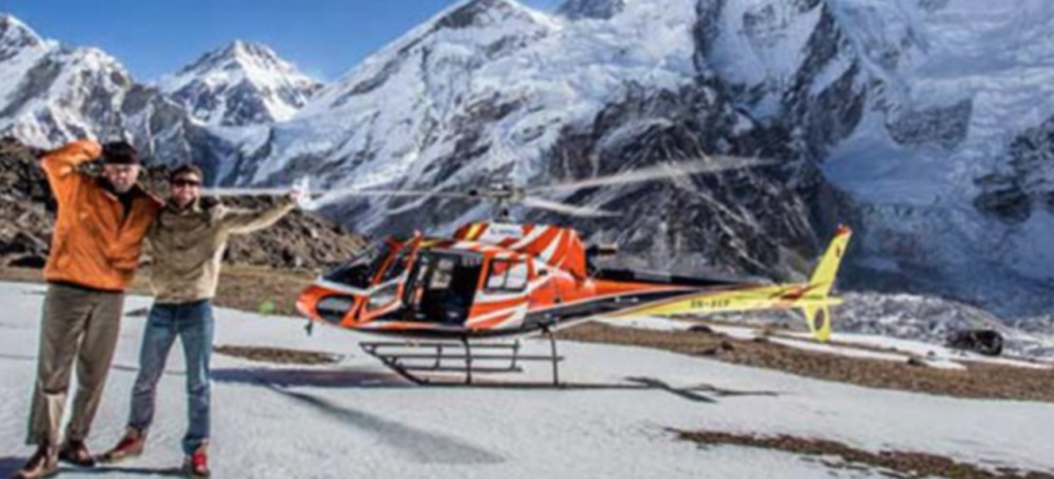 Helicopter in front of snowy mountain range