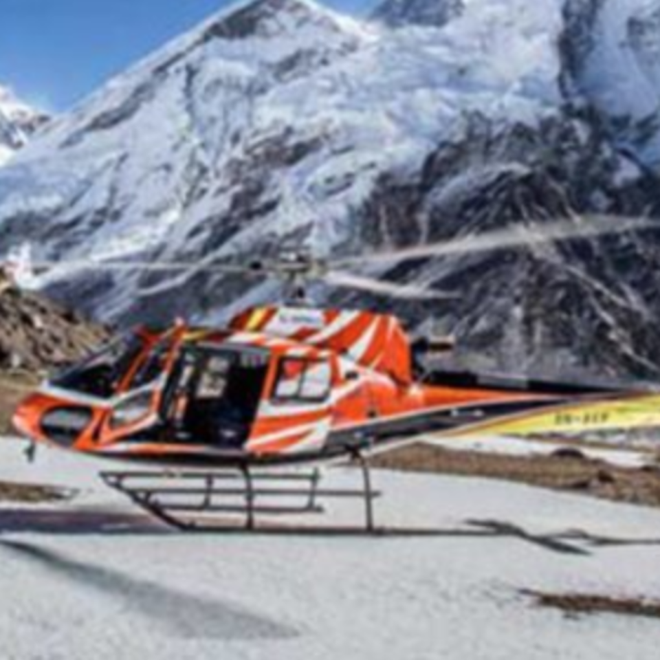 Helicopter in front of snowy mountain range